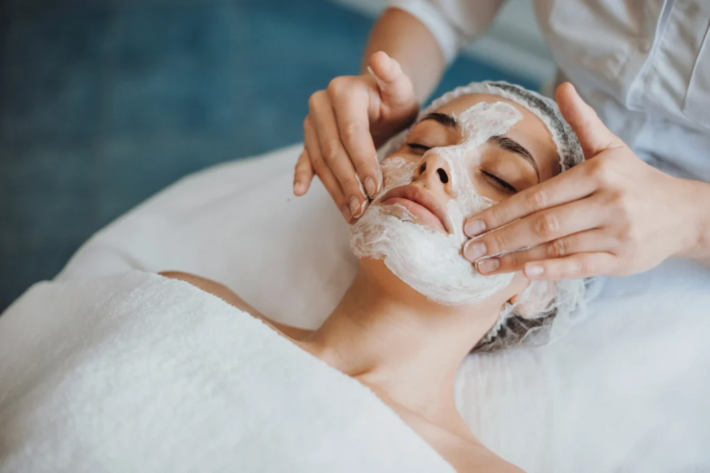 Esthetician applying a facial mask to a client during a spa treatment