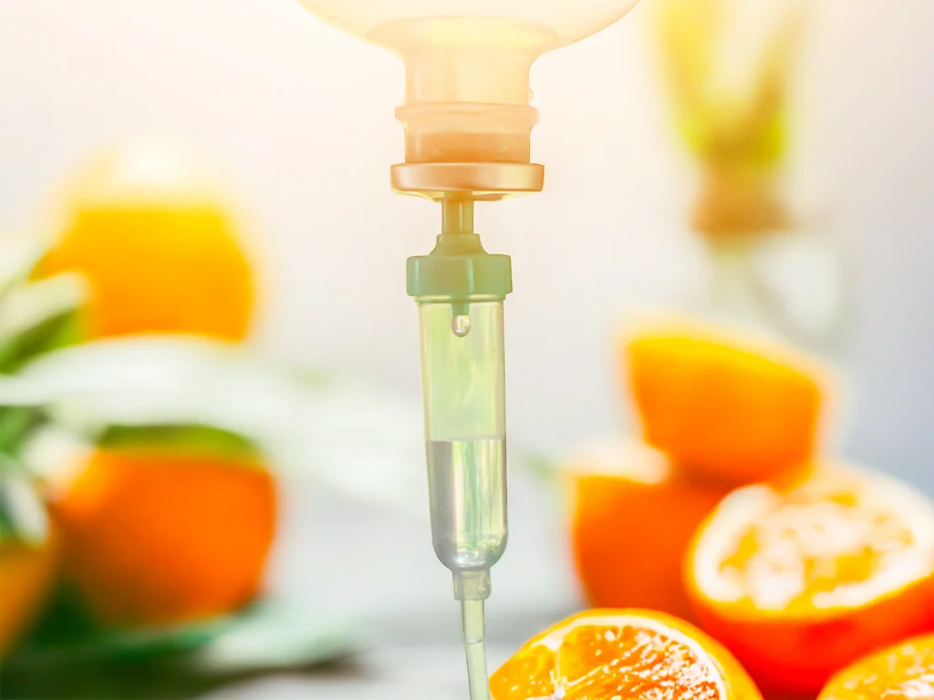 A seated person receives an IV infusion through the arm while resting in a clinical treatment environment.